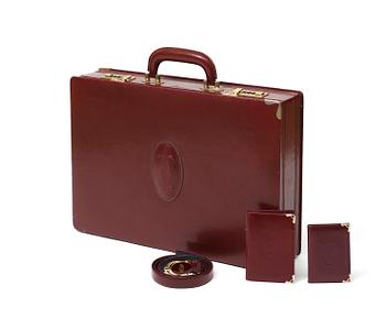 691. A wine red leather set consisting of briefcase, wallet, notepads and a belt by Cartier.