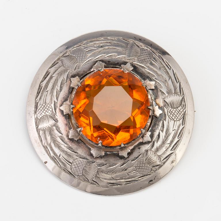 A BROOCH set with amber coloured paste.