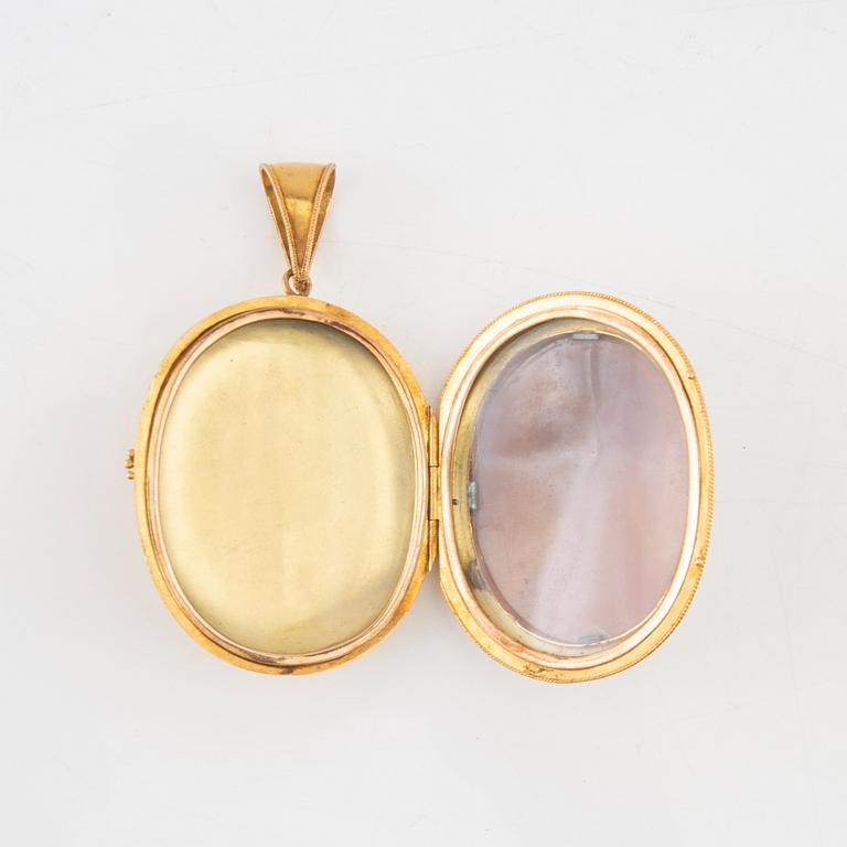 A 14K gold medallion with carved shell cameo.