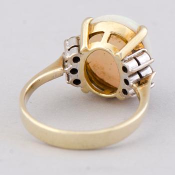 A RING, cabochon cut opal, brilliant cut diamonds, 14K gold.