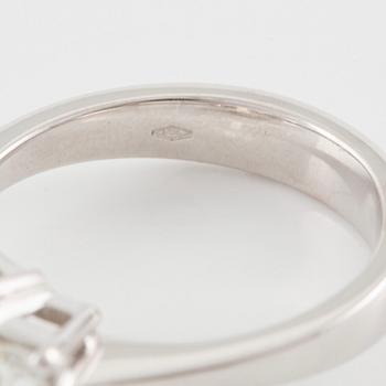 An 18K white gold ring set with three emerald-cut diamonds.