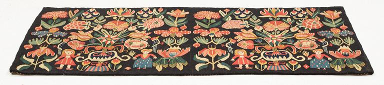 A carrige cushion, "Urnor och par", tapestry weave, ca 98 x 50 cm, around the years 1800-1825.