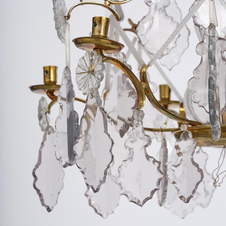 A near pair of rococo-style gilt brass and cut glass six-branch chandeliers, 19th century incorporating older elements.