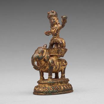 A gilt bronze figure of a deity on an elephant, presumably Nepal, 15th Century.