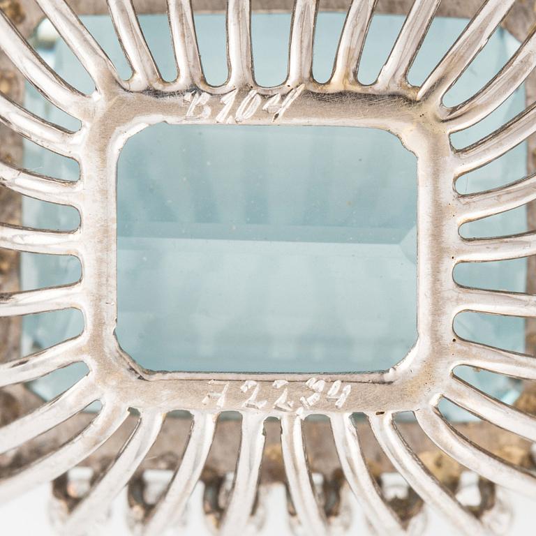 An 18K white gold Engelbert pendant set with a aquamarine and round brilliant-cut diamonds.