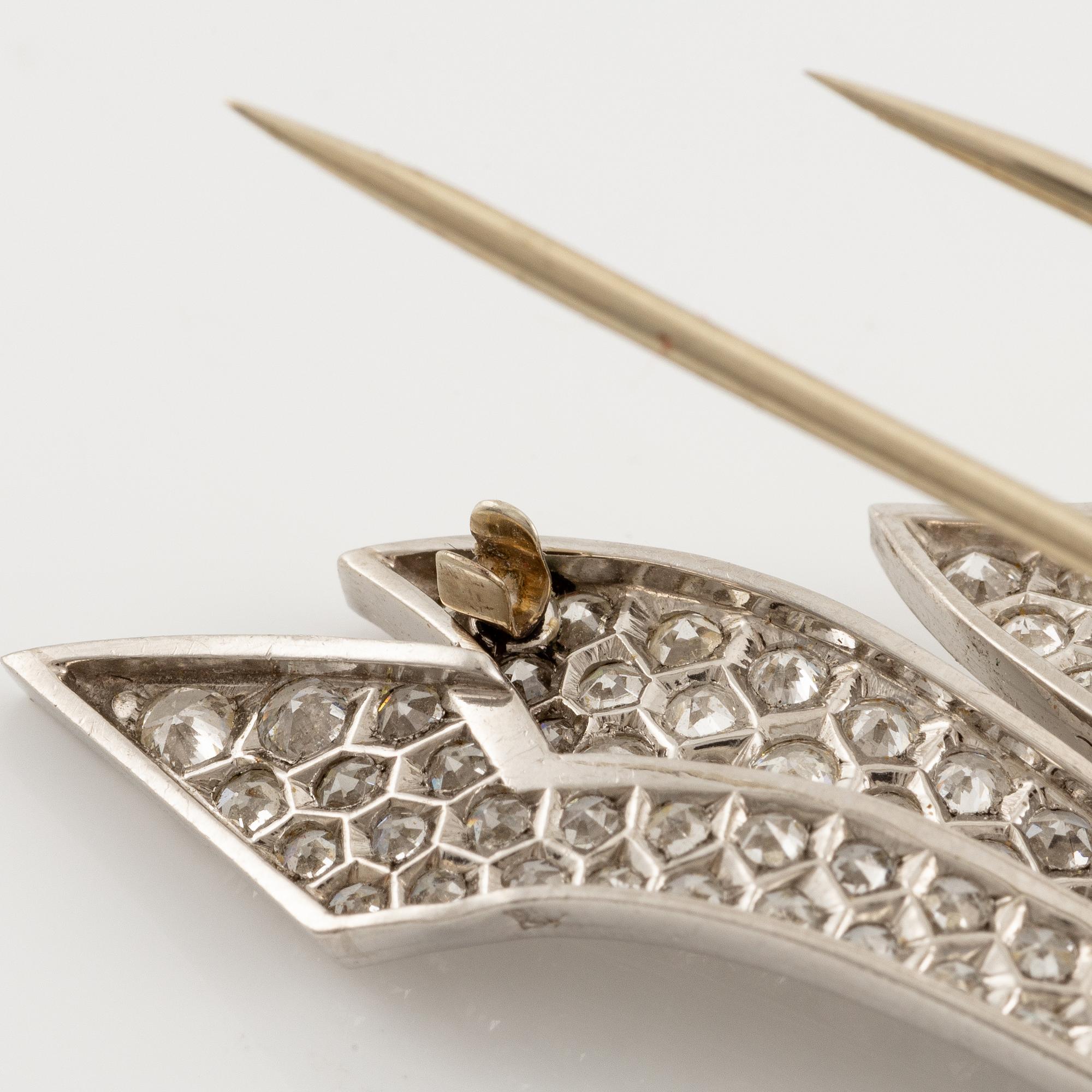 A brooch in platinum in the form of a bow with rubies and diamonds, likely from the 1950s.