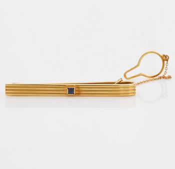 A 1960/70's tie-clip decorated with a carré-cut sapphire by Dupont, Paris.