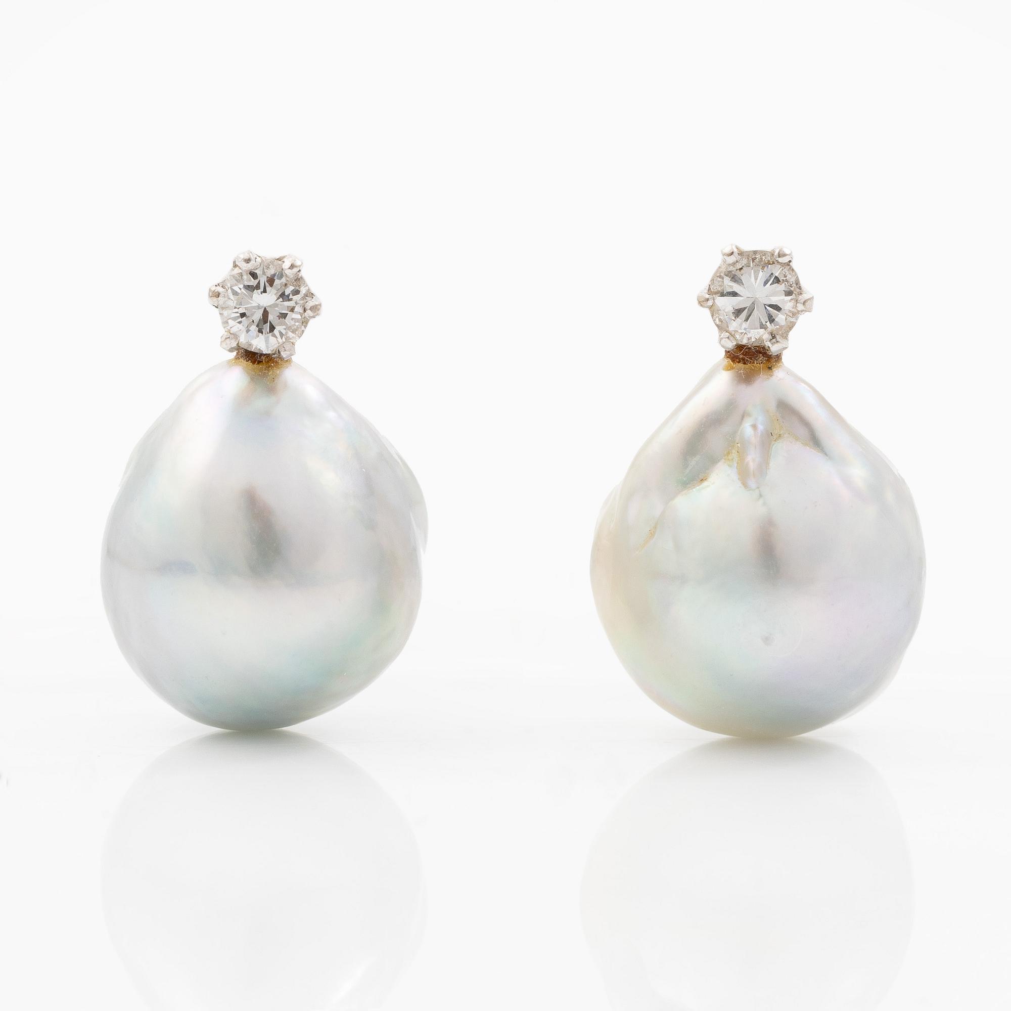 Earrings in white gold with drop-shaped grey pearls and round brilliant-cut diamonds.
