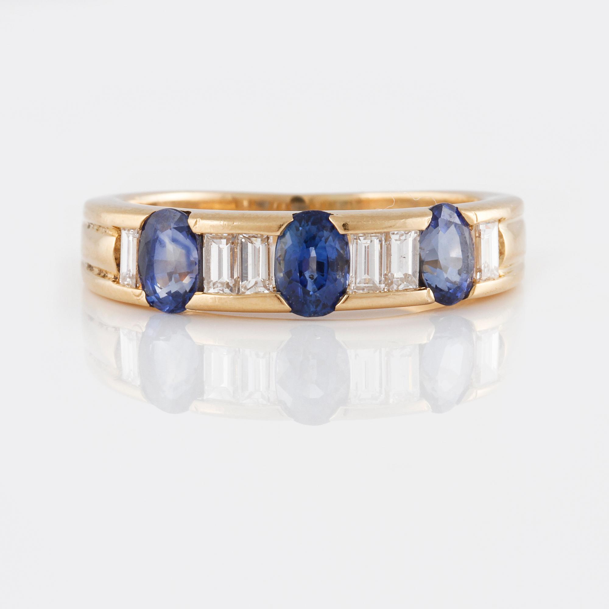 RING, 18K guld med baguetteslipade diamanter samt 3 ovalslipade blå safirer. Vikt 5,2 gram.