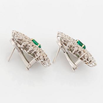 A pair of 18K white gold earrings set with faceted emeralds.