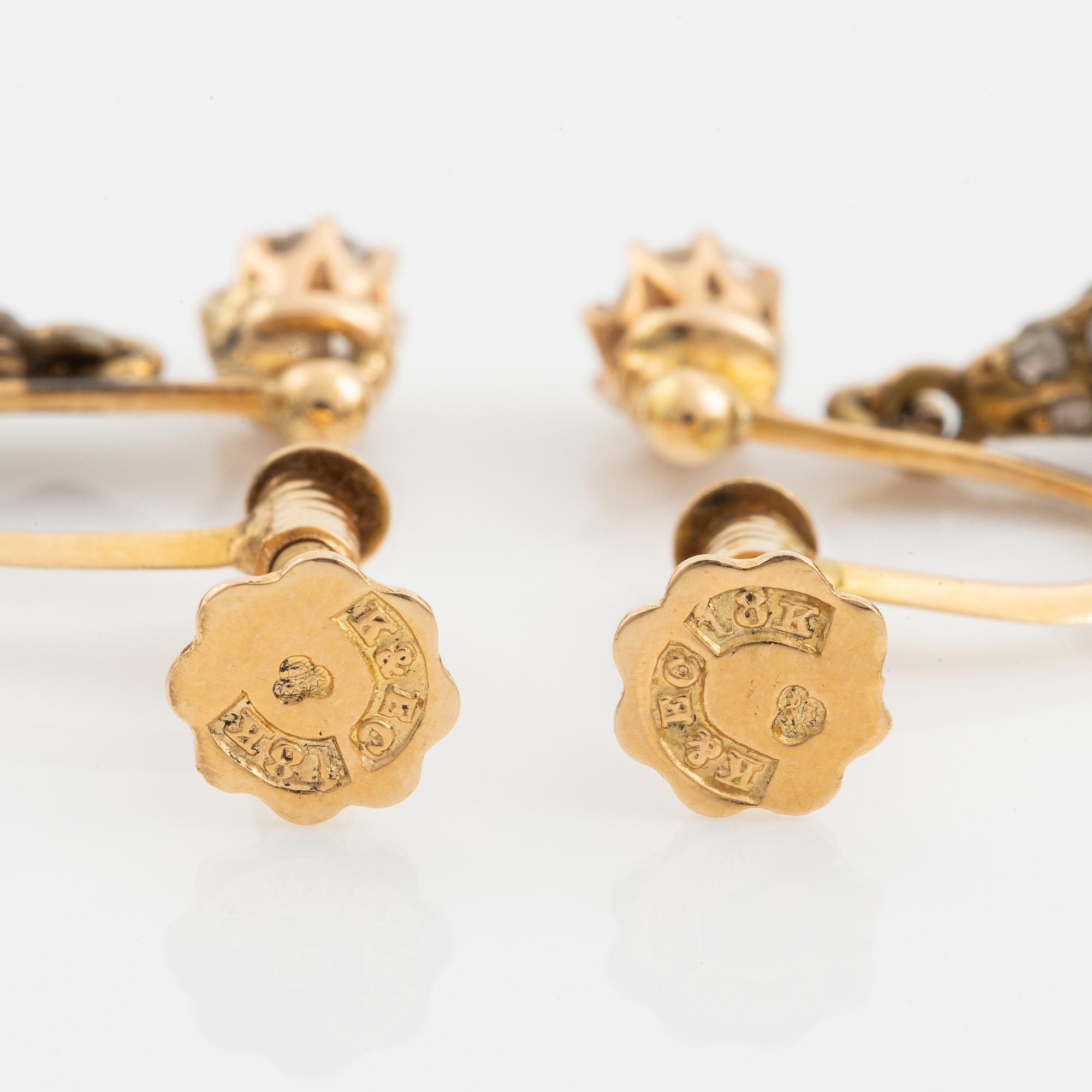 Ett par örhängen 18K guld med droppformade pärlor.