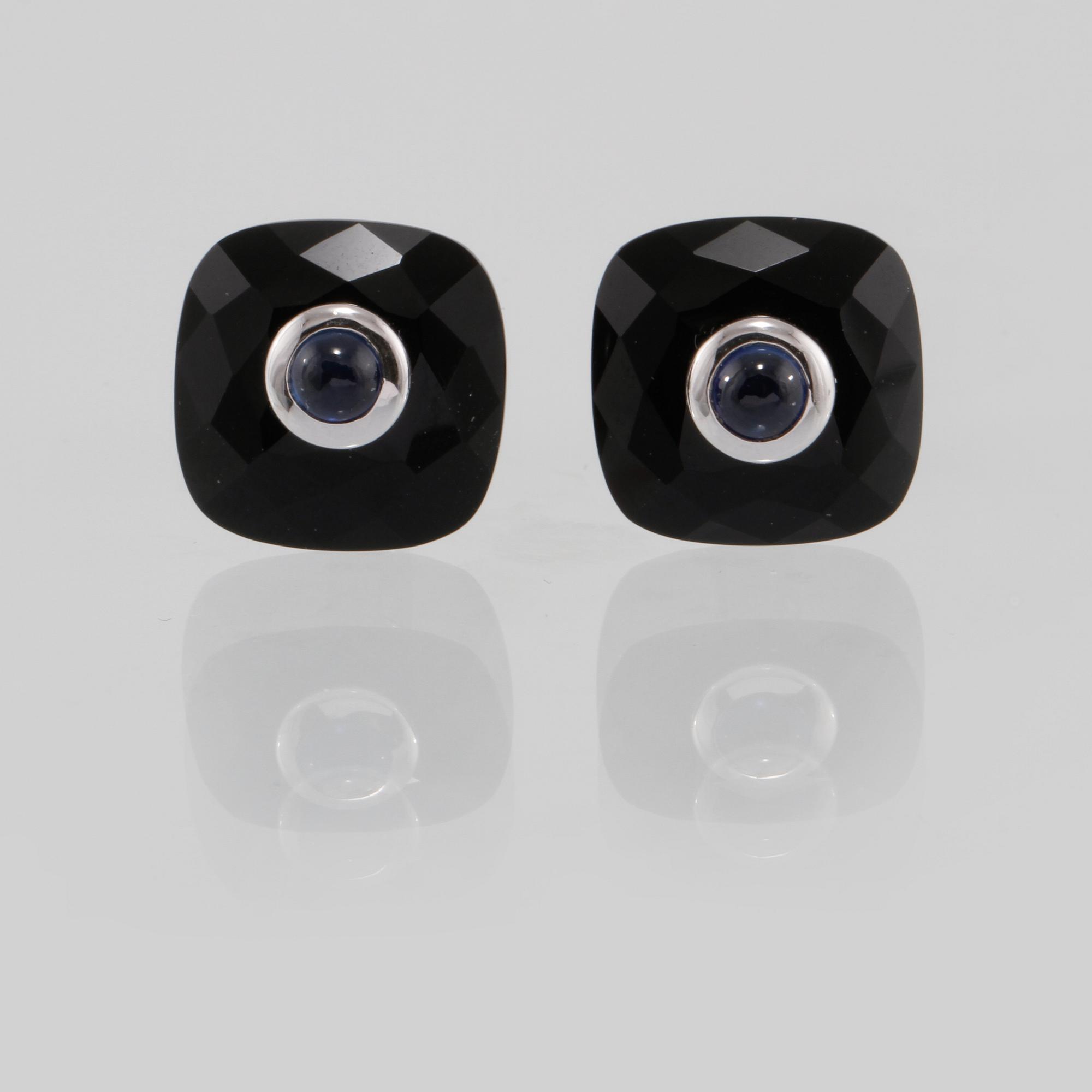 MANSCHETTKNAPPAR, 14K vitguld med checkerslipad onyx samt cabochonslipade blå safirer 0.76 ct. Vikt 8,2 gram.