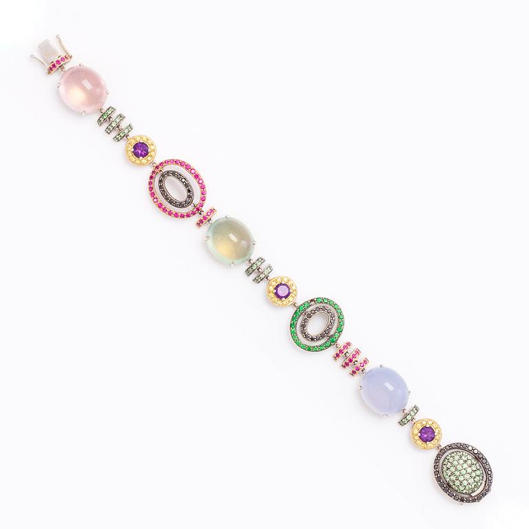 An 18K white- and yellow gold bracelet with precious and semi precious gemstones.