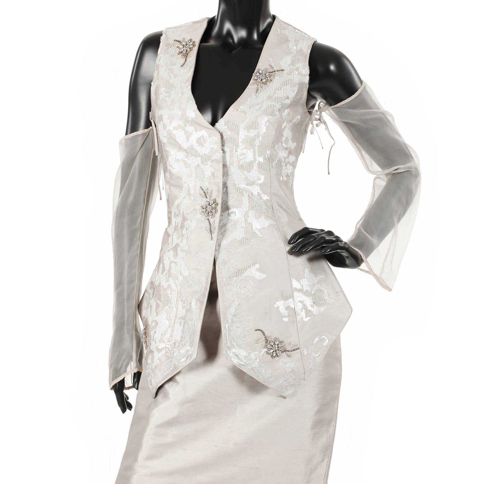 GIANFRANCO FERRÉ, a beige three-piece ensemble consisting of vest , trousers and skirt.