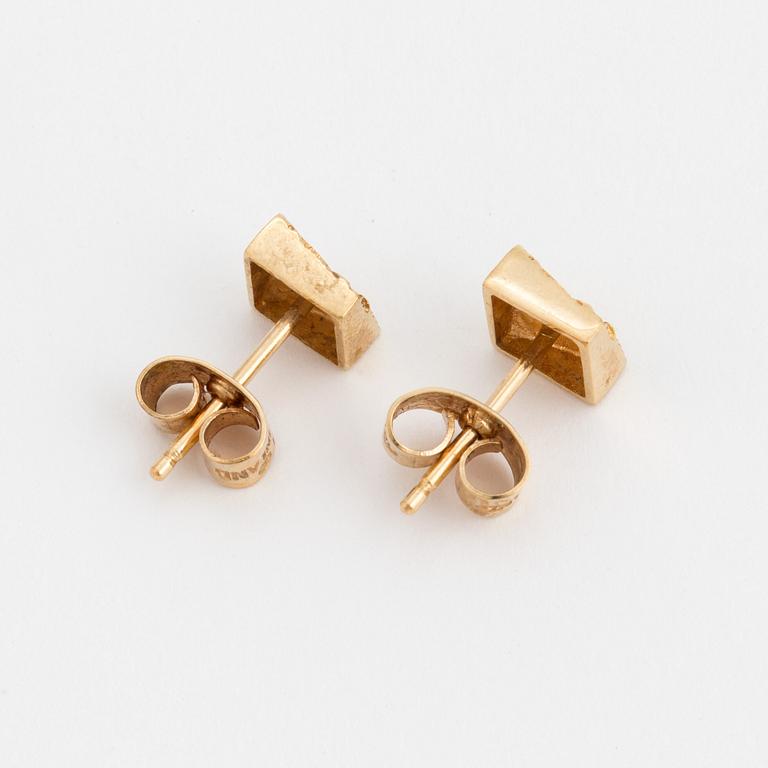 A pair of earrings with a textured surface.