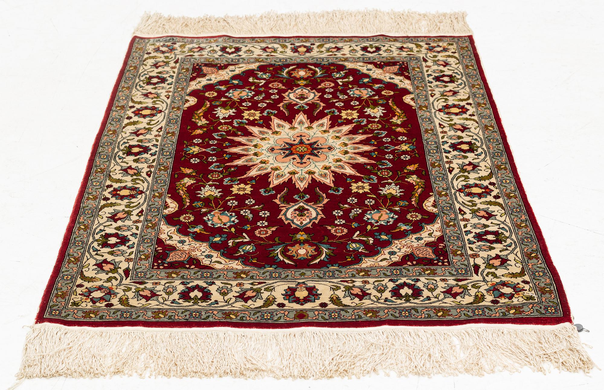 A silk Hereke rug, circa 91 x 63 cm.