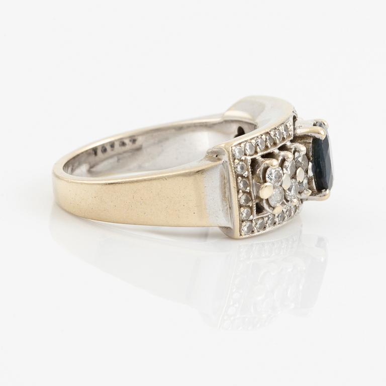 Ring with dark sapphire and brilliant-cut diamonds.