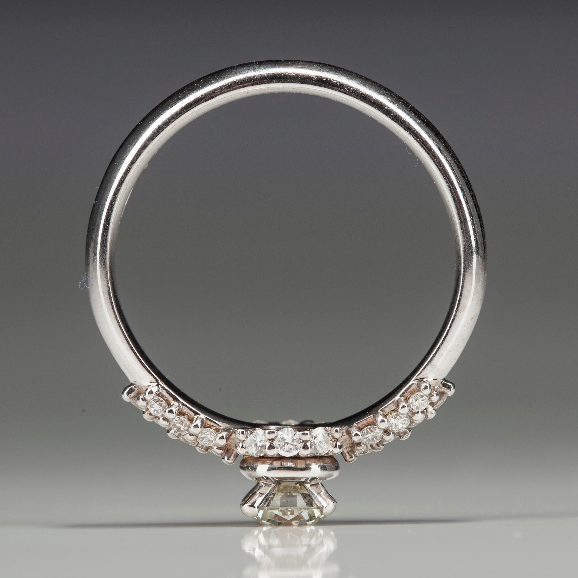 RING, vitguld 18K med diamanter. Mittstenen 0,52 ct L/SI1. 26 små diamanter tot 0,35 ct H/SI1. Intyg.