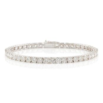 619. An 18K white gold tennis bracelet set with round brilliant-cut diamonds.