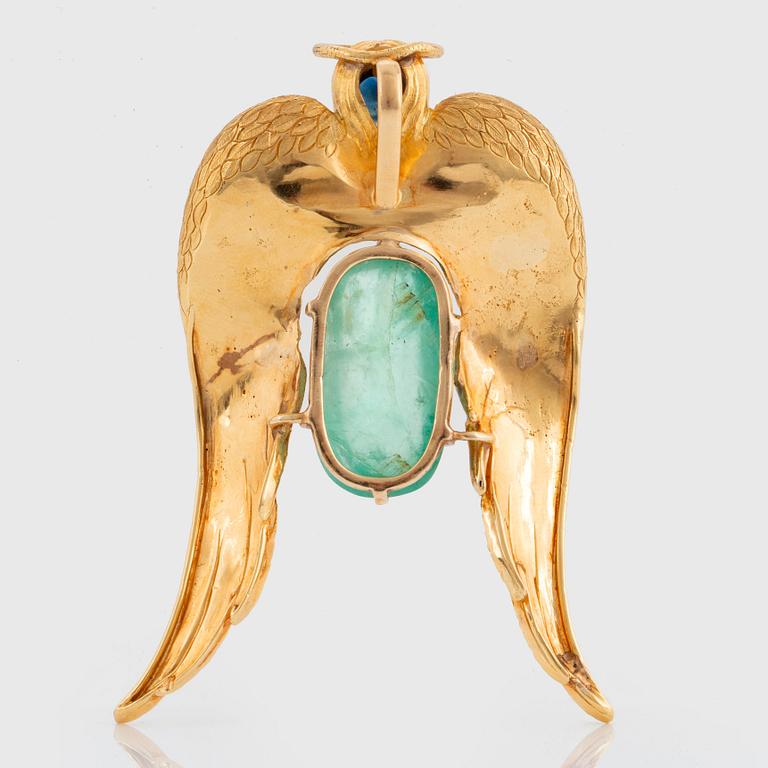 A 14K gold pendant by Salvador Dalí set with a cabochon-cut emerald and a faceted sapphire.