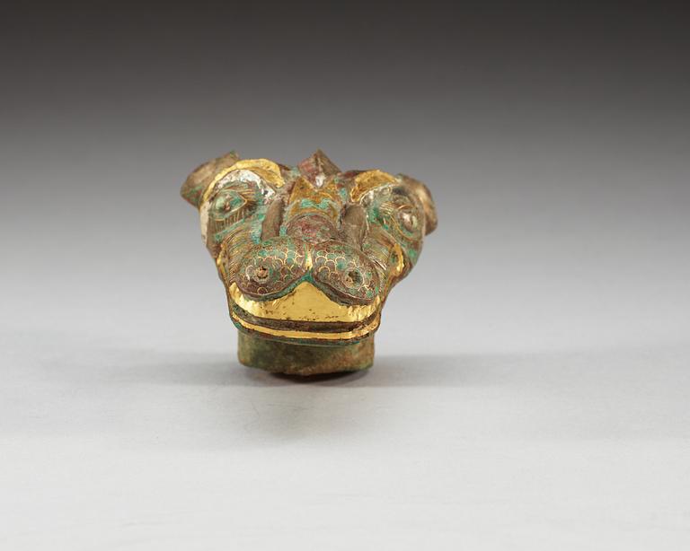 An archaistic bronze handle for a cane in the shape of a mythological animal.