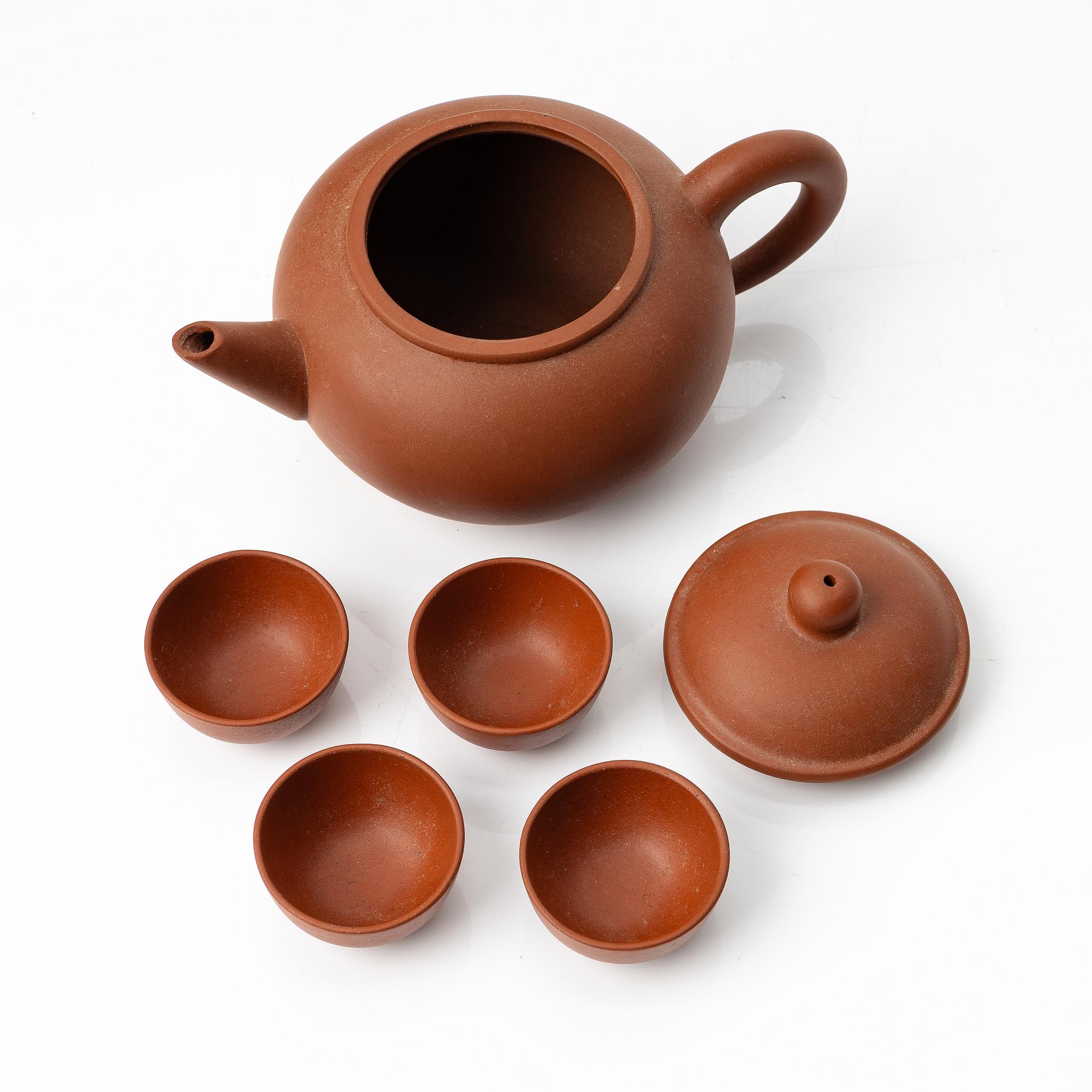 A six part red yixing Gongfu set; teapot, four cups and a tray, China, 1980s.