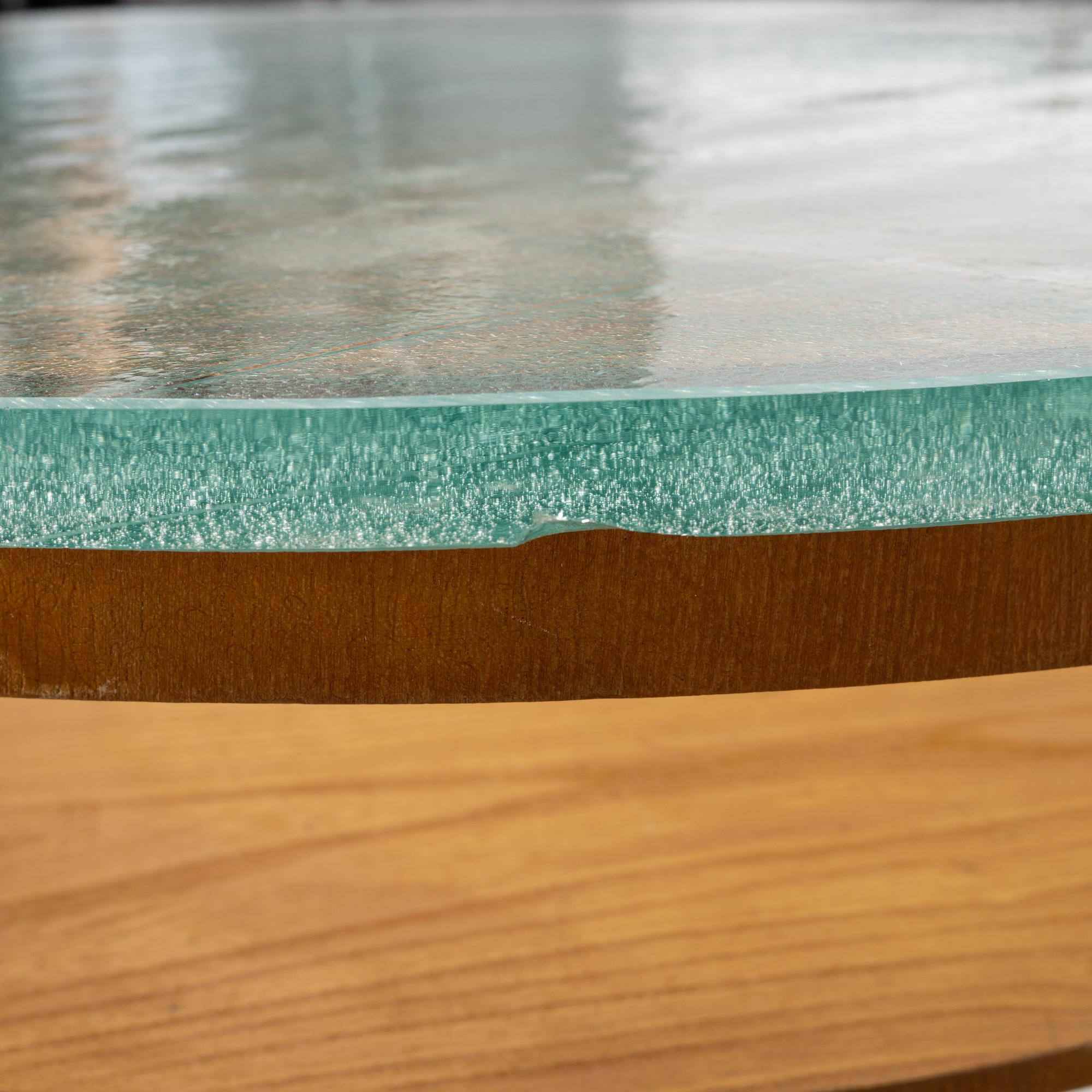 A Swedish Modern coffee table with a glass top. 1940's.