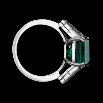 A step cut emerald app 6.00 cts, flanked by diamonds.