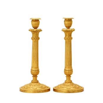 1292. A pair of French Empire early 19th century gilt bronze candlesticks.