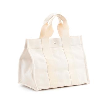 HERMÈS, a white canvas handbag.