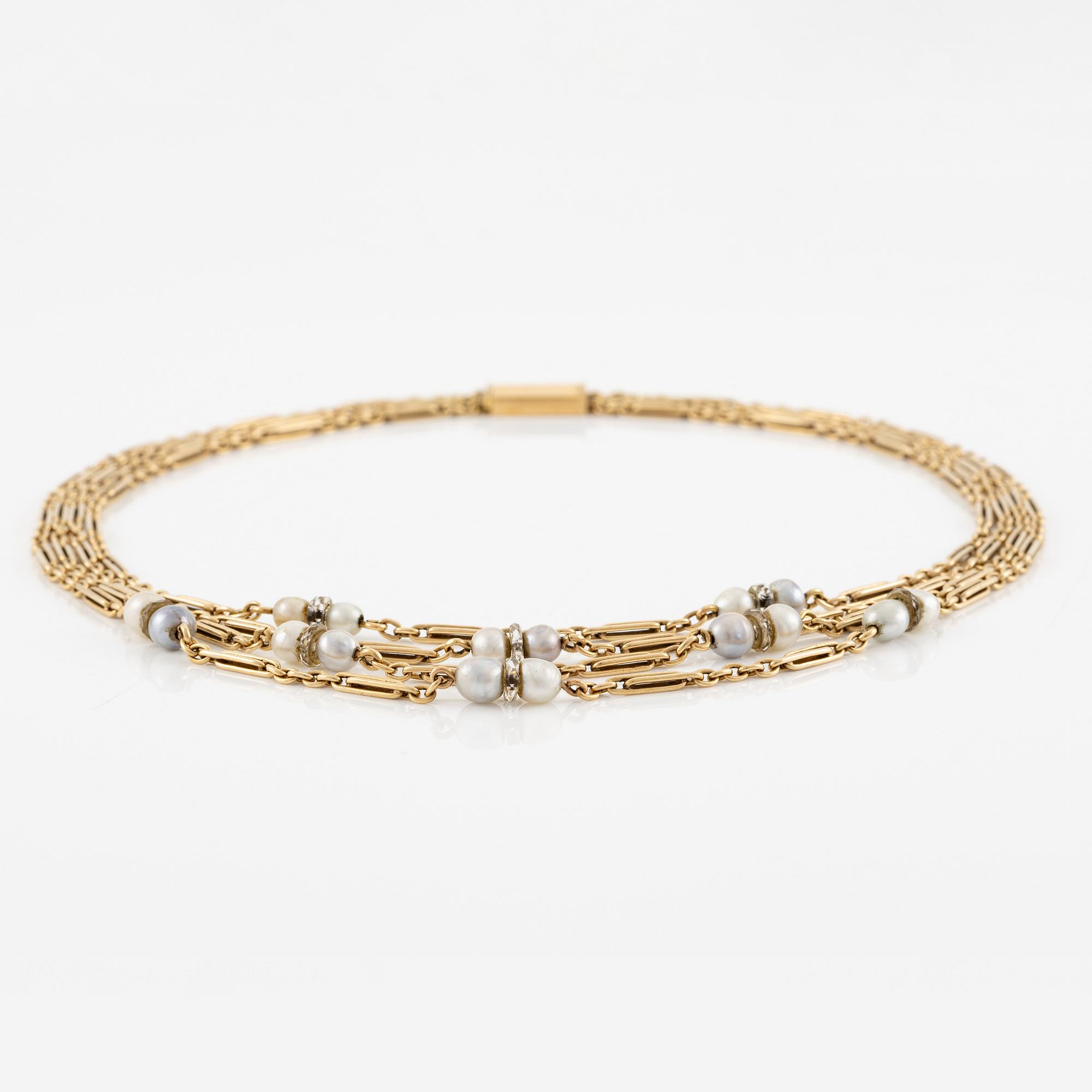 A W.A. Bolin necklace in 18K gold with pearls and white discs.