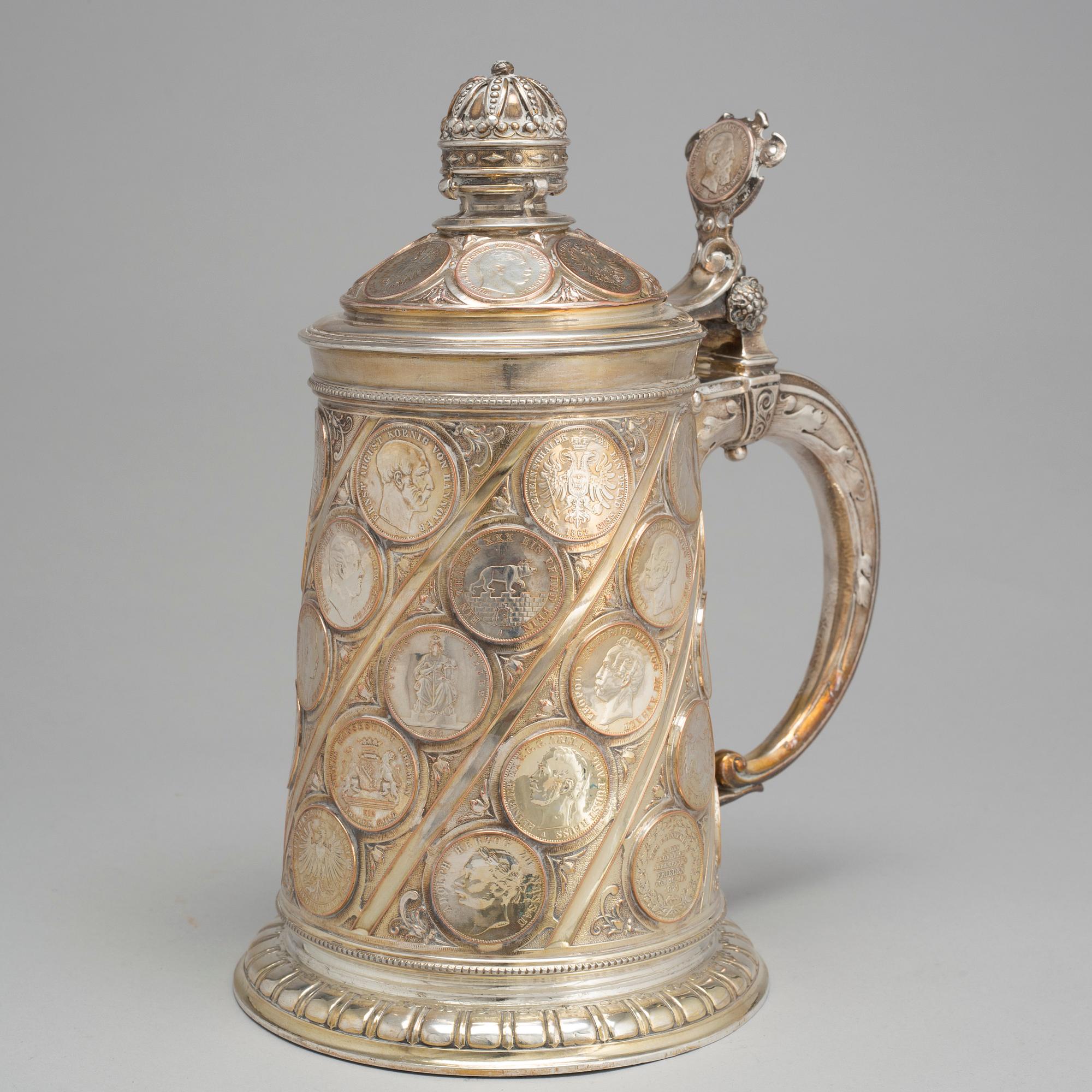 A late 19th century EPNS tankard with silver coins.