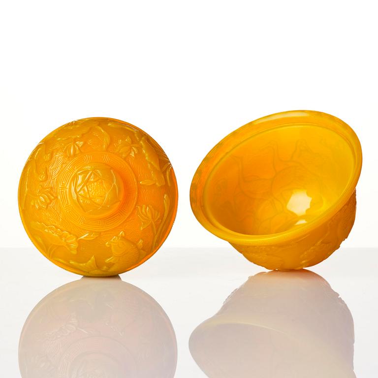 A well carved yellow glass 'crane and lotus' cup with cover, presumably late Qing dynasty.