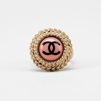 CHANEL, a gold colored logo ring.