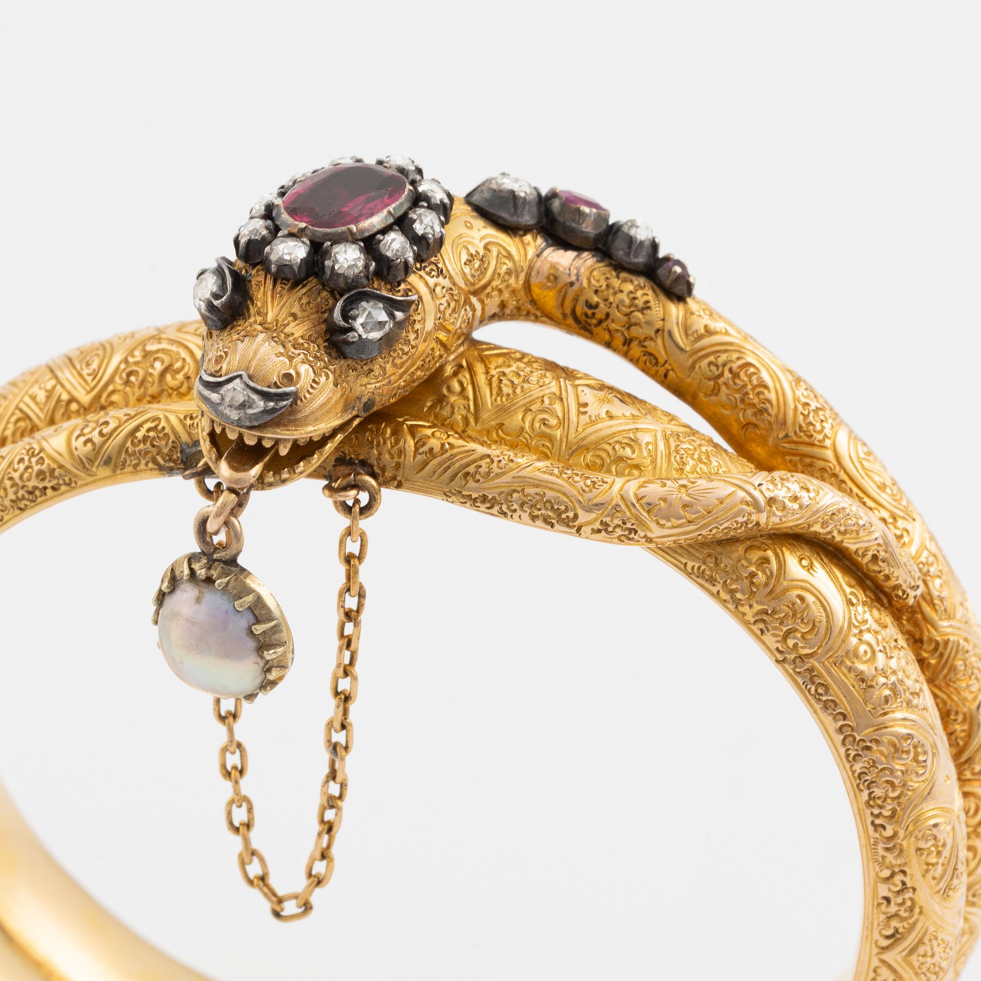 A Victorian snake bracelet in 14K gold with rose-cut diamonds, red stones and a half pearl.