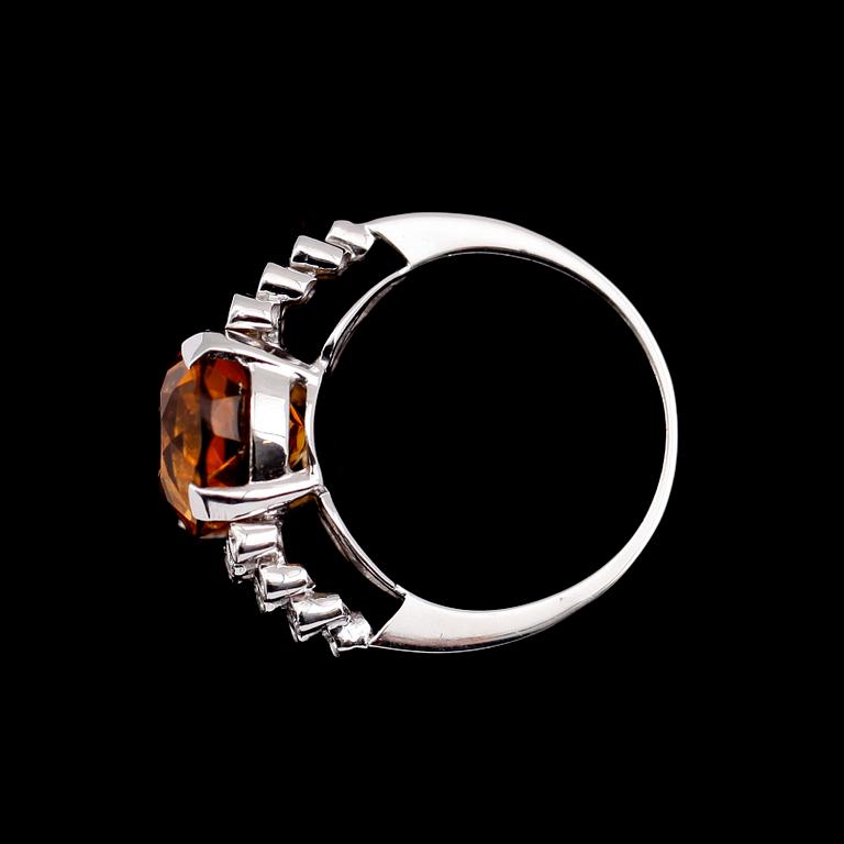 RING, 18 k vitguld, oval fasettslipad citrin ca 7.00 ct, 20 briljantslipade diamanter tot ca 0.20 ct.