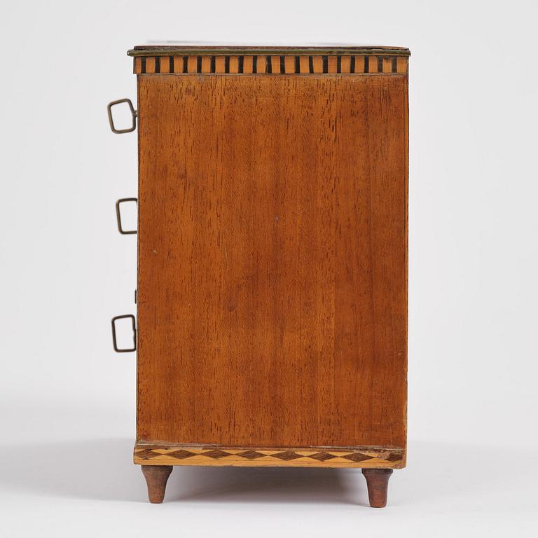 A Northern European mahogany miniature commode, early 19th century.