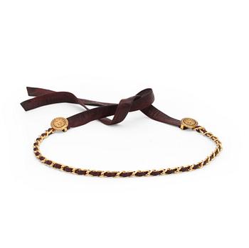 716. CHANEL, a burgundy red leather belt with gold colored metal chain.