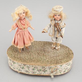 Dolls on a music box, around year 1900.