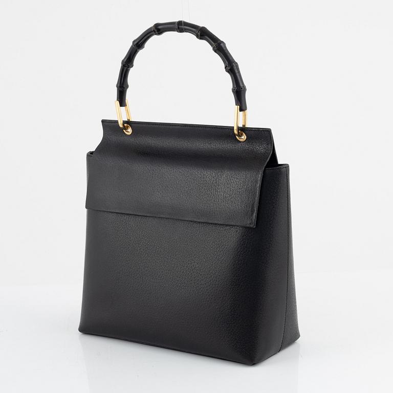 Gucci, a black leather and bamboo bag.