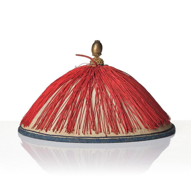 Two boxes with a mandarin's summer hat and black satin autumn hat and feather with six mandarin hat insignias.