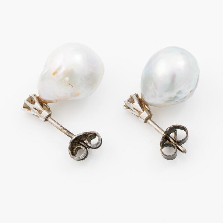 Earrings in white gold with drop-shaped grey pearls and round brilliant-cut diamonds.
