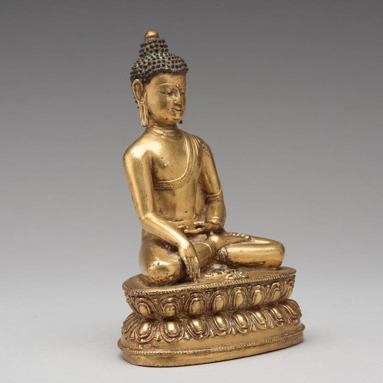 A gilt copper alloy figure of Akshobhya, Tibet, 16th Century.