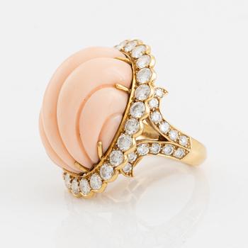 An 18K gold and coral Cartier ring set with round brilliant-cut diamonds.