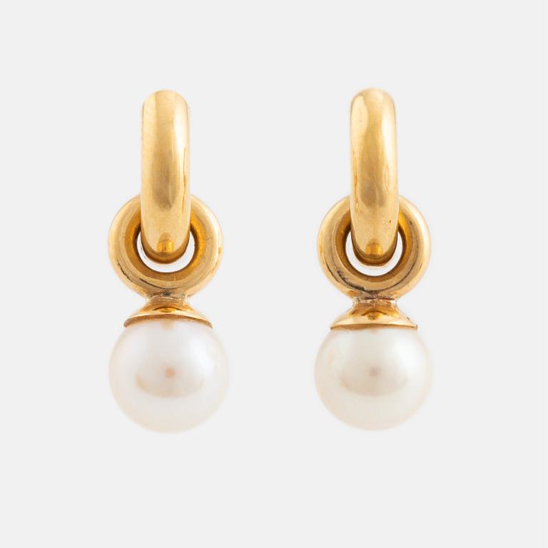 A pair of gold earrings with pearls.