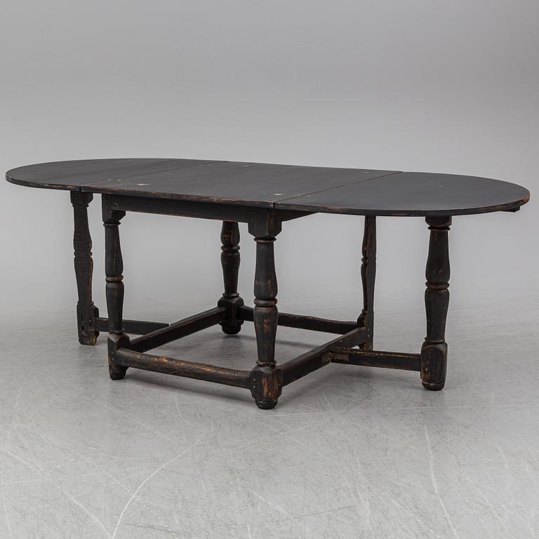 A painted pine Baroque style gate leg table, 20th Century with older parts.