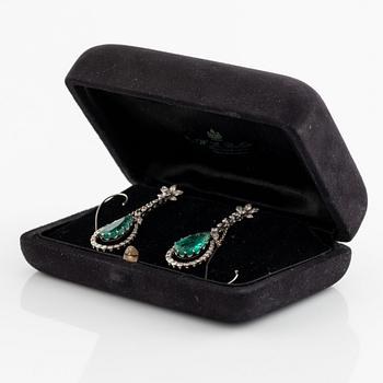 Ett par örhängen, med droppformade smaragder och diamanter.