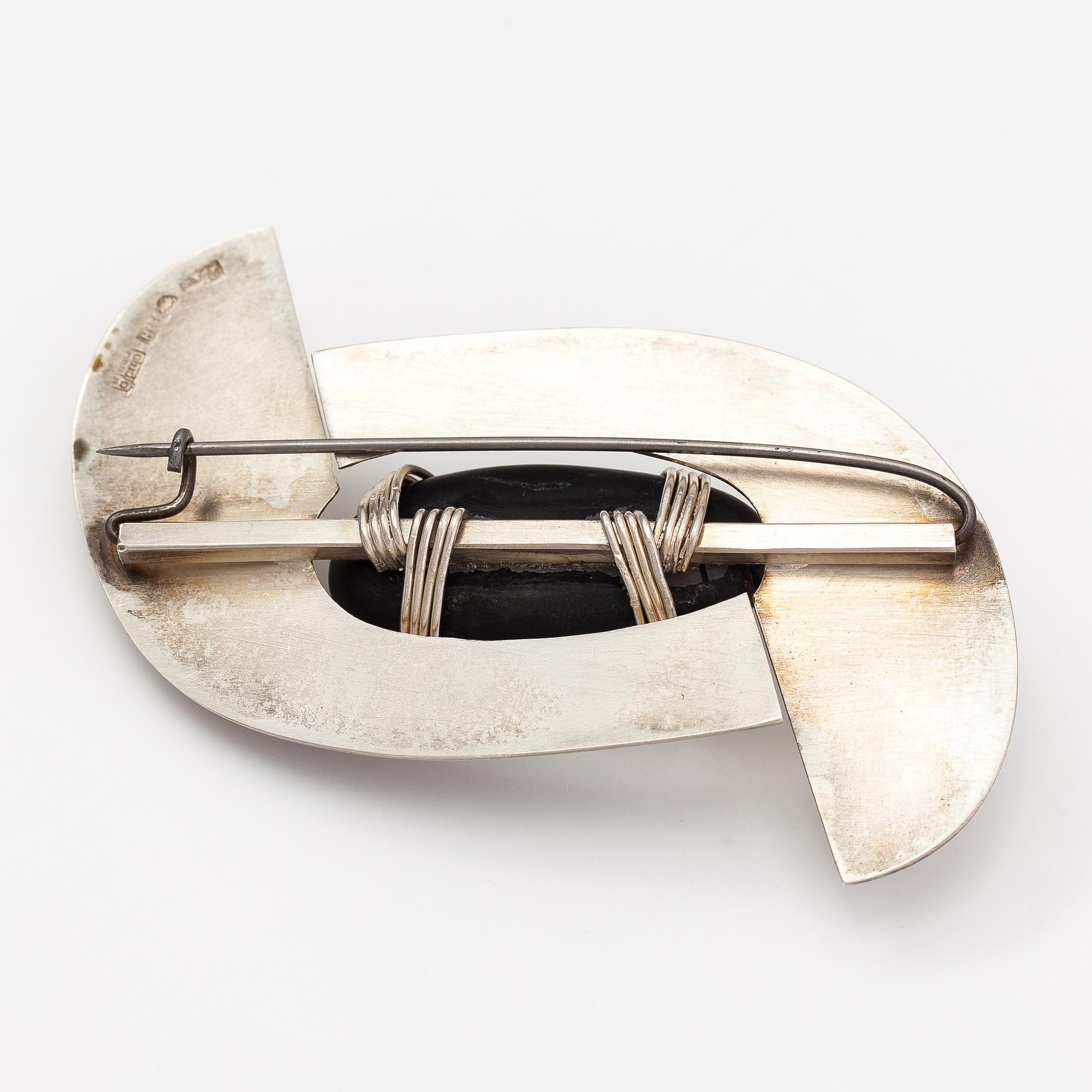 Paula Häiväoja, a sterling silver brooch with a natural stone "kiveen sidottu musta". Pentti Roos/Studio Paula, Helsinki.