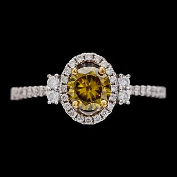 61. RING, briljantslipad gul diamant, ca 0.60 ct, samt mindre briljantslipade diamanter.