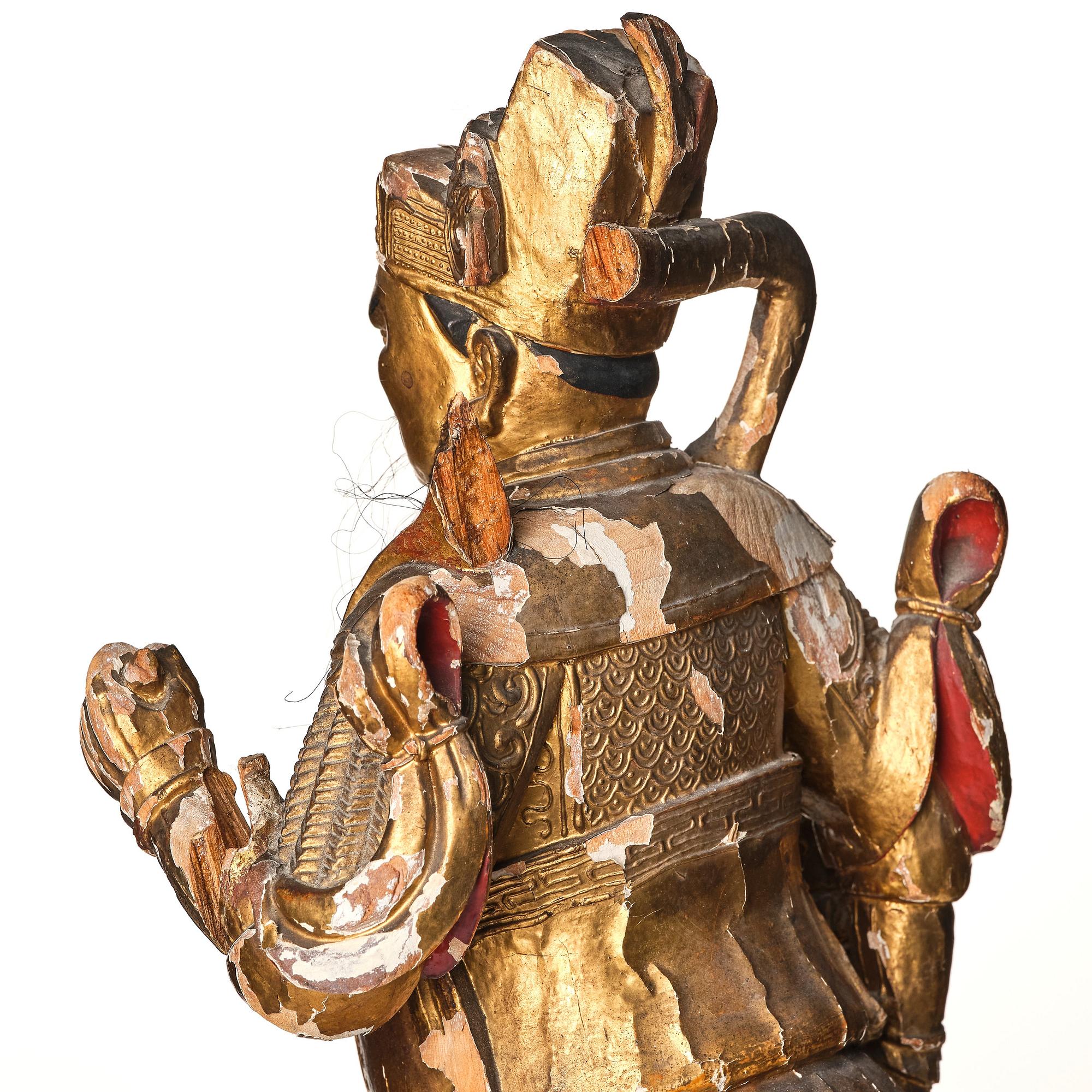 A gilt and lacquered standing figure of a guardsman, Qing dynasty.